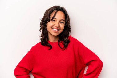 Beyaz arka planda izole edilmiş genç İspanyol kadın ellerini kalçasından ayırmıyor..