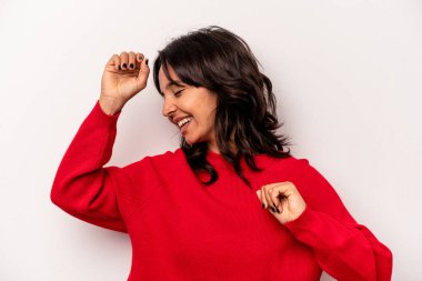 Beyaz arka planda izole edilmiş genç İspanyol kadın özel bir günü kutluyor, atlıyor ve enerjiyle kollarını kaldırıyor..