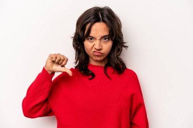Beyaz arka planda izole edilmiş genç İspanyol kadın baş parmağını aşağı gösteriyor, hayal kırıklığı konsepti.