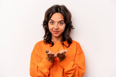 Beyaz arka planda izole edilmiş genç İspanyol kadın elinde avuç içi bir şeyle kameraya sunuyor..