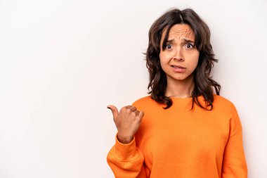 Beyaz arka planda izole edilmiş genç İspanyol kadın işaret parmağıyla fotokopi alanını işaret ederek şok oldu..