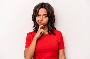 Beyaz arka planda izole edilmiş genç İspanyol kadın şüpheli, belirsiz, seni muayene ediyor..