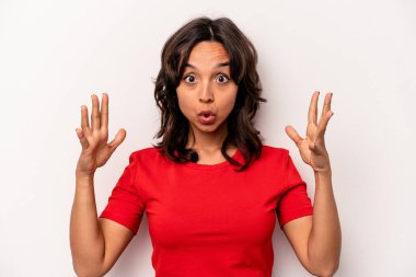 Latin kökenli genç bir kadın zaferi ya da başarıyı kutlarken beyaz arka planda mahsur kaldı. Şaşırdı ve şok oldu..