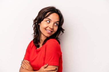 Beyaz arka planda yalnız yaşayan genç İspanyol kadın gülüyor ve eğleniyor..