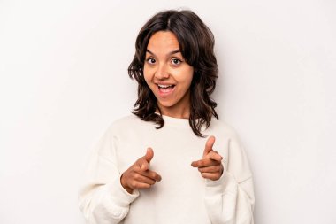 Beyaz arka planda izole edilmiş genç İspanyol kadın parmaklarıyla ön tarafı işaret ediyor..
