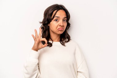 Beyaz arka planda izole edilmiş genç bir İspanyol kadın bir göz kırptı ve elleriyle iyi bir jest yaptı..