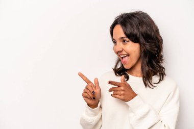 Latin kökenli genç bir kadın beyaz arka planda izole edilmiş, başparmak uzakta, gülen ve kaygısız..