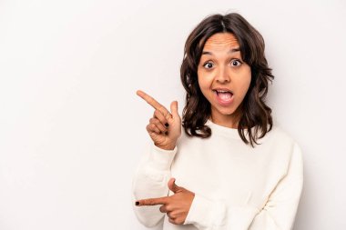 Beyaz arka planda izole edilmiş genç İspanyol kadın işaret parmaklarıyla işaret ederek heyecanlanıyor..