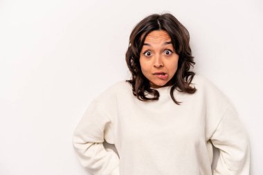 Beyaz arka planda izole edilmiş genç İspanyol kadın gördüğü bir şey yüzünden şoka uğruyor..