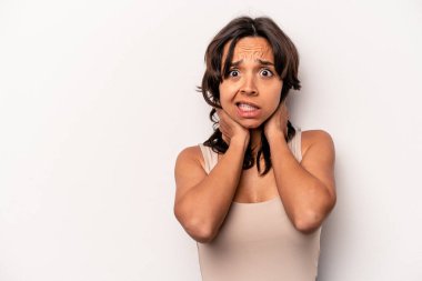 Beyaz arka planda izole edilmiş genç İspanyol kadın kafasının arkasına dokunuyor, düşünüyor ve bir seçim yapıyor..