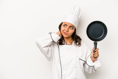 Genç İspanyol aşçı kadın beyaz arka planda izole edilmiş kafasının arkasına dokunuyor, düşünüyor ve bir seçim yapıyor..