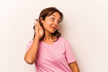 Beyaz arka planda izole edilmiş genç İspanyol kadın bir dedikoduyu dinlemeye çalışıyor..