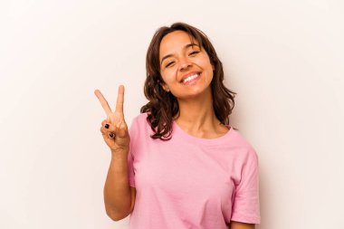 Beyaz arka planda izole edilmiş genç İspanyol kadın neşeli ve kaygısız parmakları olan bir barış sembolü gösteriyor..