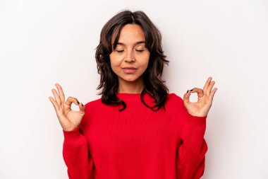 Beyaz arka planda izole edilmiş genç İspanyol kadın sıkı çalışma gününden sonra rahatlıyor, yoga yapıyor..