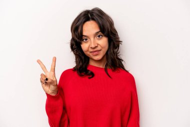 Beyaz arka planda izole edilmiş genç İspanyol kadın neşeli ve kaygısız parmakları olan bir barış sembolü gösteriyor..