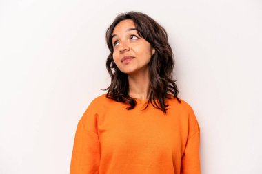 Beyaz arka planda izole edilmiş genç İspanyol kadın gevşemiş ve mutlu bir şekilde gülüyor, boynunda dişlerini gösteriyor..