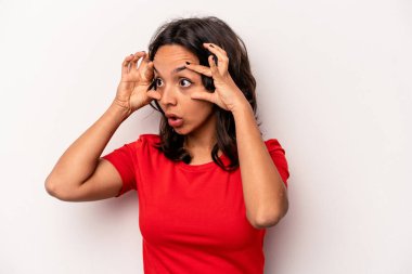 Beyaz arka planda izole edilmiş genç İspanyol kadın bir başarı fırsatı bulmak için gözlerini açık tutuyor..