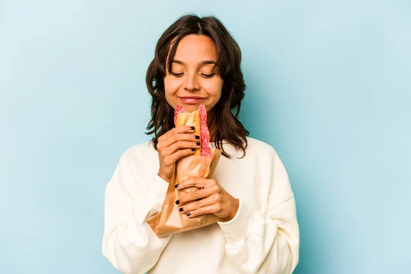 Young Hispanic Woman Eating Sandwich Isolates Blue Background — Stockfoto