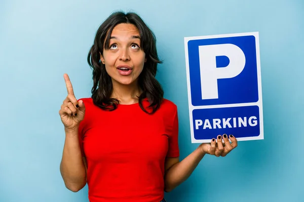 Ung Latinamerikansk Kvinna Håller Parkerings Skylt Isolerad Blå Bakgrund Pekar — Stockfoto