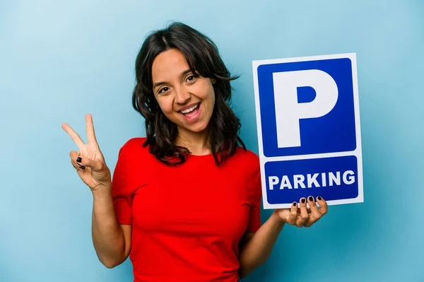 Ung Latinamerikansk Kvinna Håller Parkering Skylt Isolerad Blå Bakgrund Glad — Stockfoto