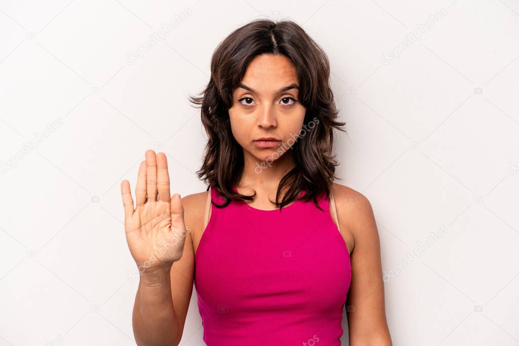 Young hispanic woman isolated on white background standing with outstretched hand showing stop sign, preventing you.