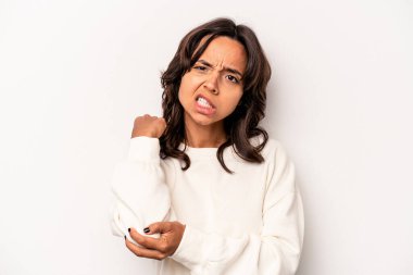 Genç İspanyol kadın beyaz arka planda izole edilmiş, dirsek masajı yapıyor, kötü bir hareketin ardından acı çekiyor..