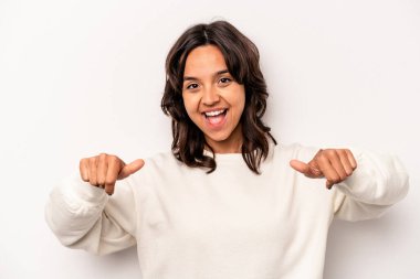 Beyaz arka planda izole edilmiş genç İspanyol kadın iki parmağını da kaldırıyor, gülümsüyor ve kendinden emin..