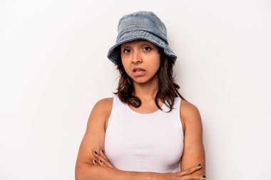 Beyaz arka planda izole edilmiş genç İspanyol kadın alaycı bir ifadeyle kameraya bakıyor..