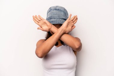 Beyaz arka planda izole edilmiş genç İspanyol kadın iki kolu çapraz tutuyor, inkar kavramı.