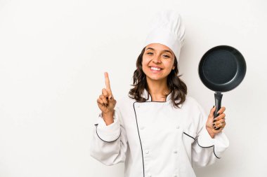Genç İspanyol aşçı kadın, beyaz arka planda izole edilmiş, parmak izleriyle bir numarayı gösteriyor..