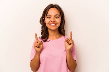 Beyaz arka planda izole edilmiş genç İspanyol kadın iki parmağı da boş bir alan gösteriyor..
