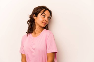 Beyaz arka planda soyutlanmış genç İspanyol kadın gülümseyen, neşeli ve keyifli bir kenara bakıyor..