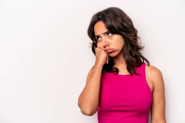 Beyaz arka planda izole edilmiş genç İspanyol kadın üzgün ve dalgın hissediyor, kopyalama alanına bakıyor..