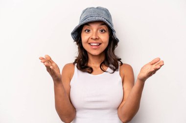 Latin kökenli genç bir kadın zaferi ya da başarıyı kutlarken beyaz arka planda mahsur kaldı. Şaşırdı ve şok oldu..