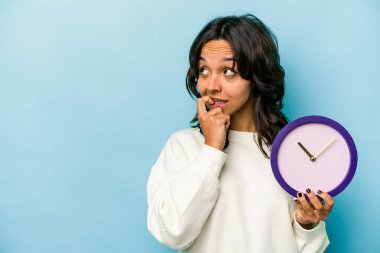 Mavi arka planda izole edilmiş bir saat tutan genç İspanyol kadın bir şeyin fotokopi odasına baktığını düşünerek rahatladı..