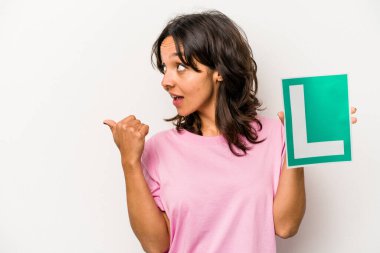 Genç İspanyol kadın elinde acemi sürücü işareti ile beyaz arka plan noktalarına izole edilmiş baş parmak uzakta, gülen ve kaygısız.