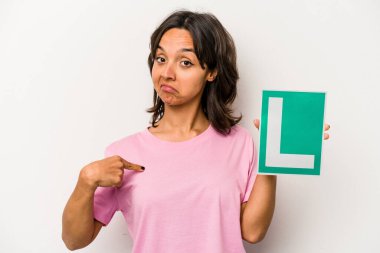 Beyaz arka plandaki izole edilmiş beyaz arka planda, gururlu ve kendinden emin bir şekilde tişört fotokopi alanını işaret eden genç İspanyol kadın.