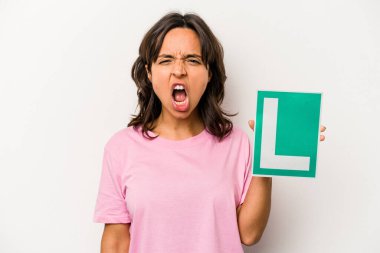 Genç İspanyol kadın elinde acemi sürücü tabelası var. Beyaz arka planda izole edilmiş. Çok sinirli ve agresif bağırıyor..