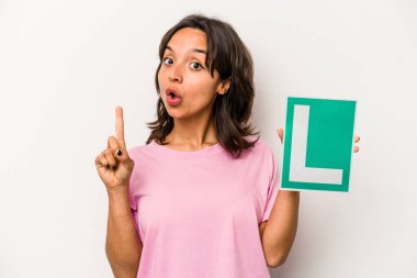 Beyaz arka planda izole edilmiş acemi sürücü tabelasını tutan İspanyol genç bir kadın. Harika bir fikir, yaratıcılık kavramı var..