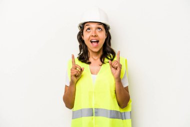 Beyaz arka planda izole edilmiş genç işçi kadın ağzı açık bir şekilde üst tarafı işaret ediyor..