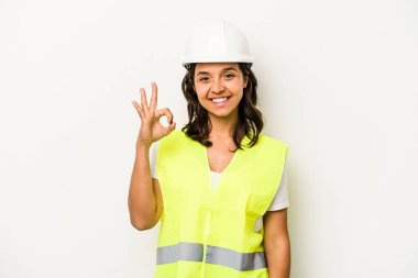 Latin kökenli genç bir kadın beyaz arka planda izole edilmiş neşeli ve kendinden emin bir şekilde iyi bir hareket gösteriyor..