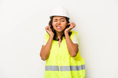 Latin kökenli genç bir kadın. Beyaz arka planda izole edilmiş. Kulaklarını elleriyle kapatıyor..