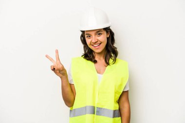 Latin kökenli genç bir kadın beyaz arka planda izole edilmiş neşeli ve kaygısız parmaklarıyla barış sembolü gösteriyor..