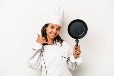 Beyaz arka planda izole edilmiş genç İspanyol aşçı kadın parmaklarıyla bir cep telefonu hareketi gösteriyor..