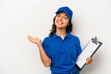 Beyaz arka planda izole edilmiş genç İspanyol kadın teslimatçı bir avuç içinde fotokopi alanı ve belinde bir el daha gösteriyor..