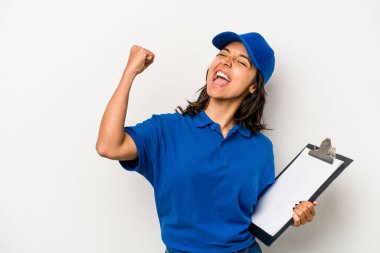 Genç İspanyol kadın teslimatçı beyaz arka planda izole edilmiş zafer kazandıktan sonra yumruğunu kaldıran, kazanan konsept..