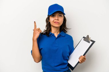 Beyaz arka planda izole edilmiş genç İspanyol kadın teslimatçı işaret parmağıyla bir hayal kırıklığı gösteriyor..