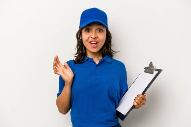 Genç İspanyol kadın teslimatçı beyaz arka planda izole edilmiş şaşırmış ve şok olmuş..