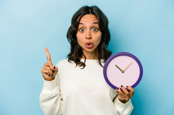 Young Hispanic Woman Holding Clock Isolated Blue Background Having Some — Stok fotoğraf