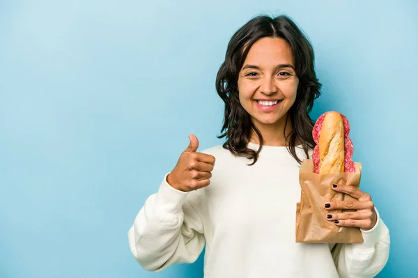 Young Hispanic Woman Eating Sandwich Isolates Blue Background Smiling Raising — Photo